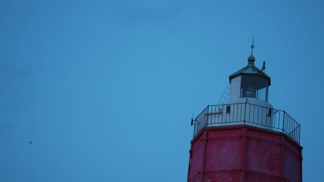 Close up of old lighthouse blinking in the dusk