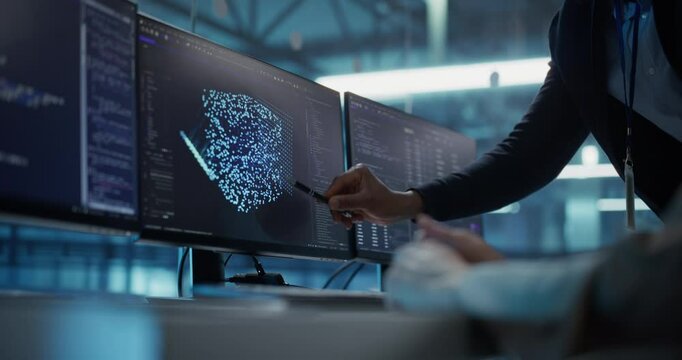 Anonymous Female and Male Software Developers Working on an AI Model Displayed Across Multiple Monitors. Professionals Working on a Project in a Data Center Office