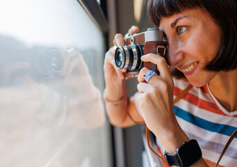 train ride. young woman enjoying train ride and holding camera. camera close up.