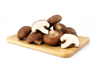 Fresh shiitake mushrooms on a wooden tray isolated on white background.