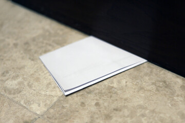 Letter envelope slipped under the door. Secret information from an anonymous person. Information...