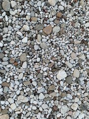 Different sized grey brownish pebbles on the beach