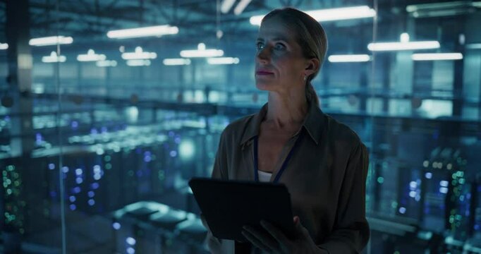 Portrait of a Female Systems Administrator Standing in a Glass Office, Adjusting Configuration Settings on Her Tablet Computer, Operating Cloud Services Servers for Artificial Intelligence Training