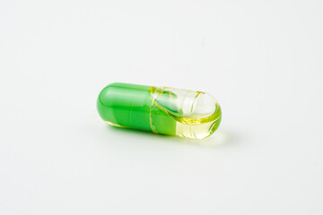Transparent capsules with a mixture of green powder and oil, Food supplements, vitamins