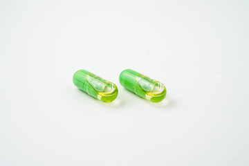 Transparent capsules with a mixture of green powder and oil, Food supplements, vitamins