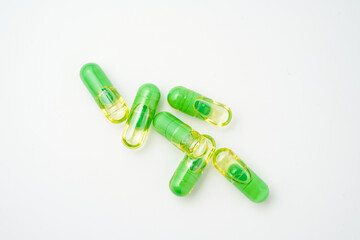 transparent pills with a mixture of green powder and oil, Food supplements, vitamins and minerals