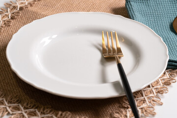 empty round white plate on tablecloth 
