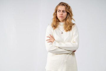 Half-length portrait of dissatisfied young attractive blonde girl on white background