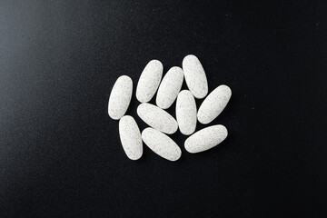 Antibiotic white pills Medicine tablet capsules in blister pack on a black background