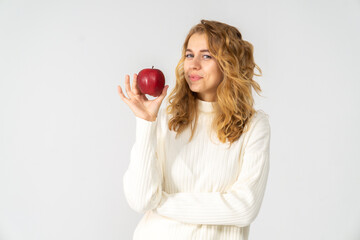 Happy attractive blonde young girl holding a red apple, white background, copyspace