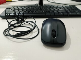 wireless mouse and keyboard with headset on white table