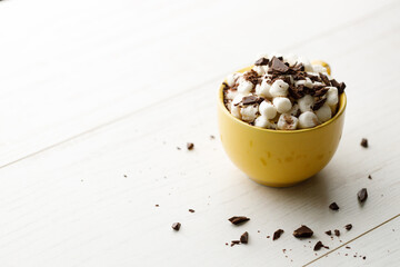 Cocoa and marshmallows in yellow ceramic cup