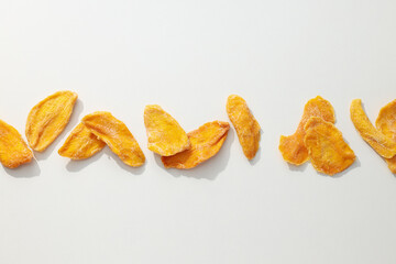 Dried mango chips on a white background
