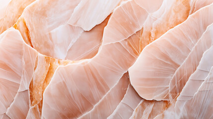 Close-up view of smooth and textured surfaces of translucent orange and white marble stone with intricate natural patterns and layers.