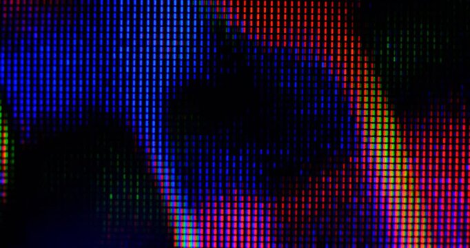 macro view of 4K LED matrix red, blue, and green sub-pixels, monitor, or TV screen. Colored pixels texture creates an abstract pattern.