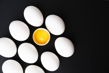 background of white chicken eggs and yolk in the shell. High quality photo. Black Background. Minimalism