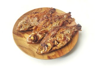 Fried fish on a wooden plate isolated on white background 
