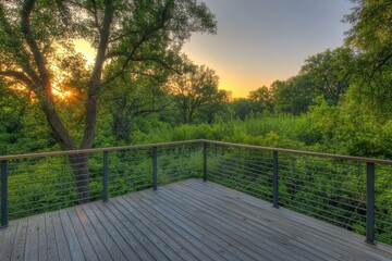 Obraz premium A serene wooden deck overlooks a lush green landscape at sunset, creating a tranquil outdoor retreat.