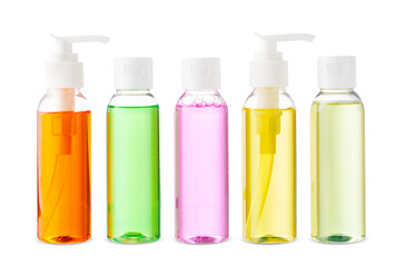 Variety of colorful personal care bottles and grooming accessories arranged on a white surface