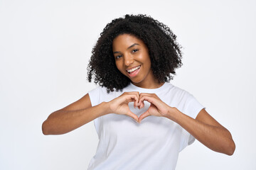 Happy young African American woman wearing t-shirt showing heart sign hand gesture standing...