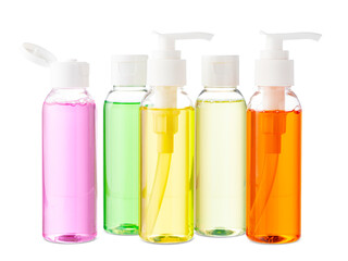 Variety of colorful personal care bottles and grooming accessories arranged on a white surface