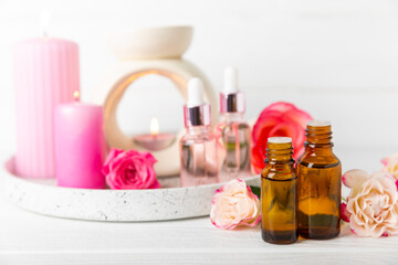 Rose essential oil on a textured background.Roses and a bottle of rose perfumed water.Aromatherapy treatment. Beauty concept. Spa procedure.Natural organic oil.Anti-stress,detox relax.Place for text
