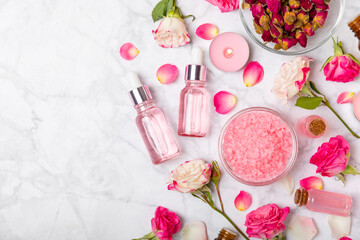 Rose essential oil on a textured background.Roses and a bottle of rose perfumed water.Aromatherapy treatment. Beauty concept. Spa procedure.Natural organic oil.Anti-stress,detox relax.Place for text