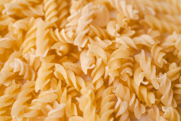 Pile of dry rotini yellow pasta over isolated white background. High quality photo