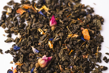 A set of different types of green, black and herbal tea next to the kettle filled with hot brewed tea on a white background. Delicious organic drinks. View from above. A place for text. High quality