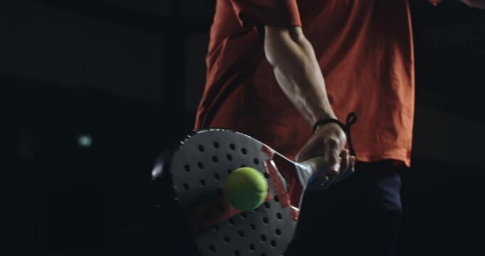 Super slow motion close up of paddle player is hitting ball during competition game match or training workout on indoor court at 1000 fps.