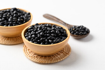 Black bean in wooden bowl with spoon on white background, Food ingredient
