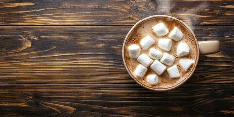 A steaming cup of hot chocolate topped with marshmallows is placed on a dark wooden table, seen from above. Enjoy the delightful sight from an overhead perspective.
