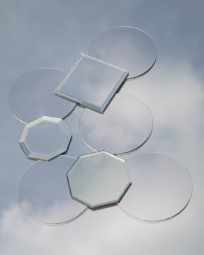 art background with set of small mirrors placed on large mirror reflecting the blue sky and clouds