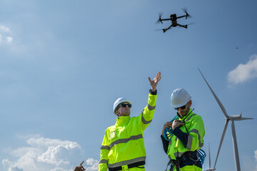 Maintenance engineer team working at wind turbine farm. Skill people using drone flying navigating above alternative renewable energy wind power station. Sustainable clean energy technology. Ecology