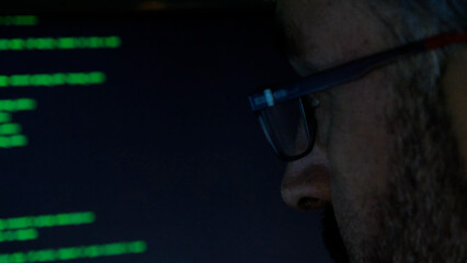 Focused Coder Analyzes Code on Computer Screen in Dark Environment - Cyber security, Cyber Attack, Penetration testing concept.