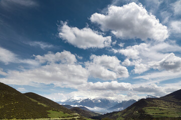 A village on the slopes of the mountain, cloudy sky, meadows and trees