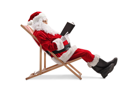 Santa claus sitting on a beach chair and reading a book