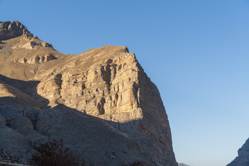 Chegsem Gorge. El-Tyubu Unique rocky ridge is located in heart of Caucasus Mountains in Kabardino-Balkaria. Beautiful and majestic steep rock against blue sky glows in sun. Close-up. Sunset