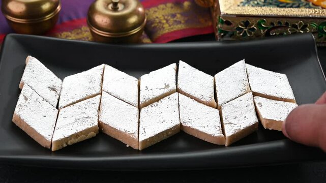 Serving Kaju Katli sweet dish in a plate.