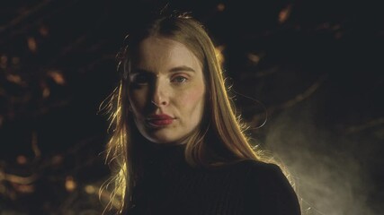 Fashion model poses in nature, showcasing her beauty with eyes both closed and open. Dressed in a black turtleneck sweater, she embodies elegance and confidence amidst the serene backdrop