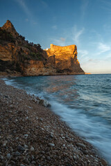 The rock rises above the blue sea