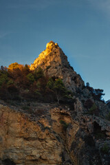The rock rises above the blue sea