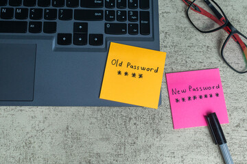 handwritten old and new password code sticky notes on laptop keyboard. concept of password security...