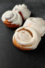 Fragrant Cinnabons with cream on a gray background