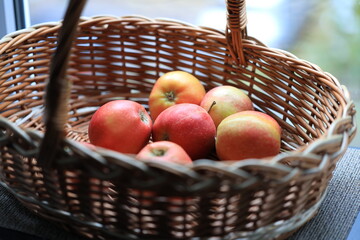 A basket of fresh apples sitting on a windowsill, perfect for a kitchen or dining room.