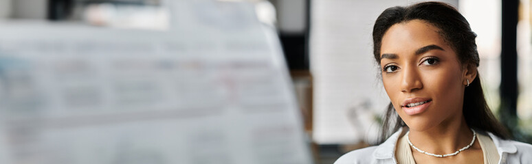 A young, beautiful woman focuses intently while collaborating in a vibrant office space.