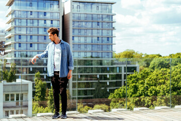 Young man on rooftop with urban landscape in background