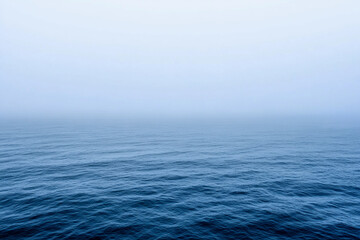 Fototapeta premium Calm ocean waves under a misty morning sky