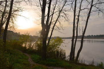 Sunset over the water. Beautiful landscape. The path goes into the distance.