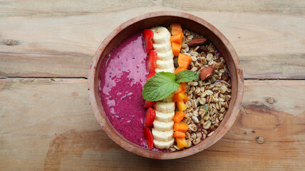 Healthy breakfast bowl: dragon fuit smoothie with banana, strawberry, almonds, mango and chia seeds. top view